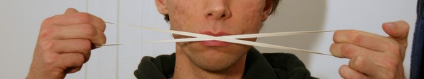 holding a rubber band against my lips and stretching it