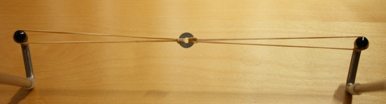 Two stretched rubber bands connected by a metalic ring